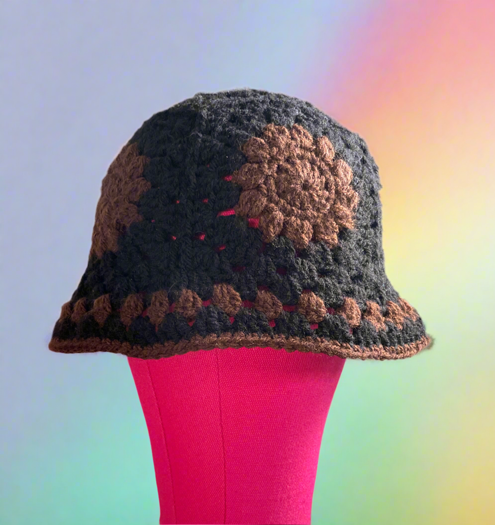 Crocheted hat with a sunflower design on a mannequin against a colorful background